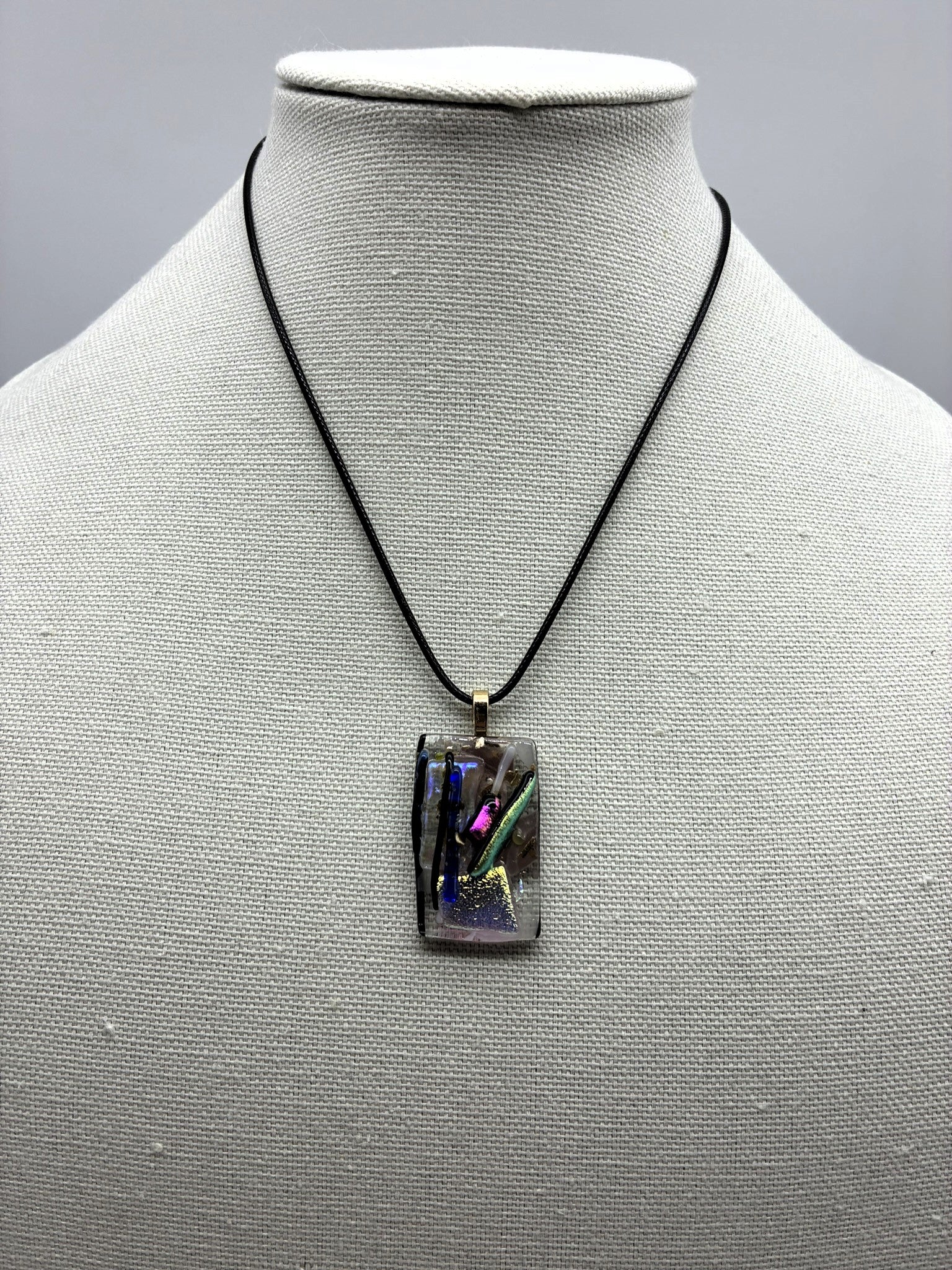 Jewelry - Small clear glass rectangle holding silver pot with a number colored sticks coming out of it.