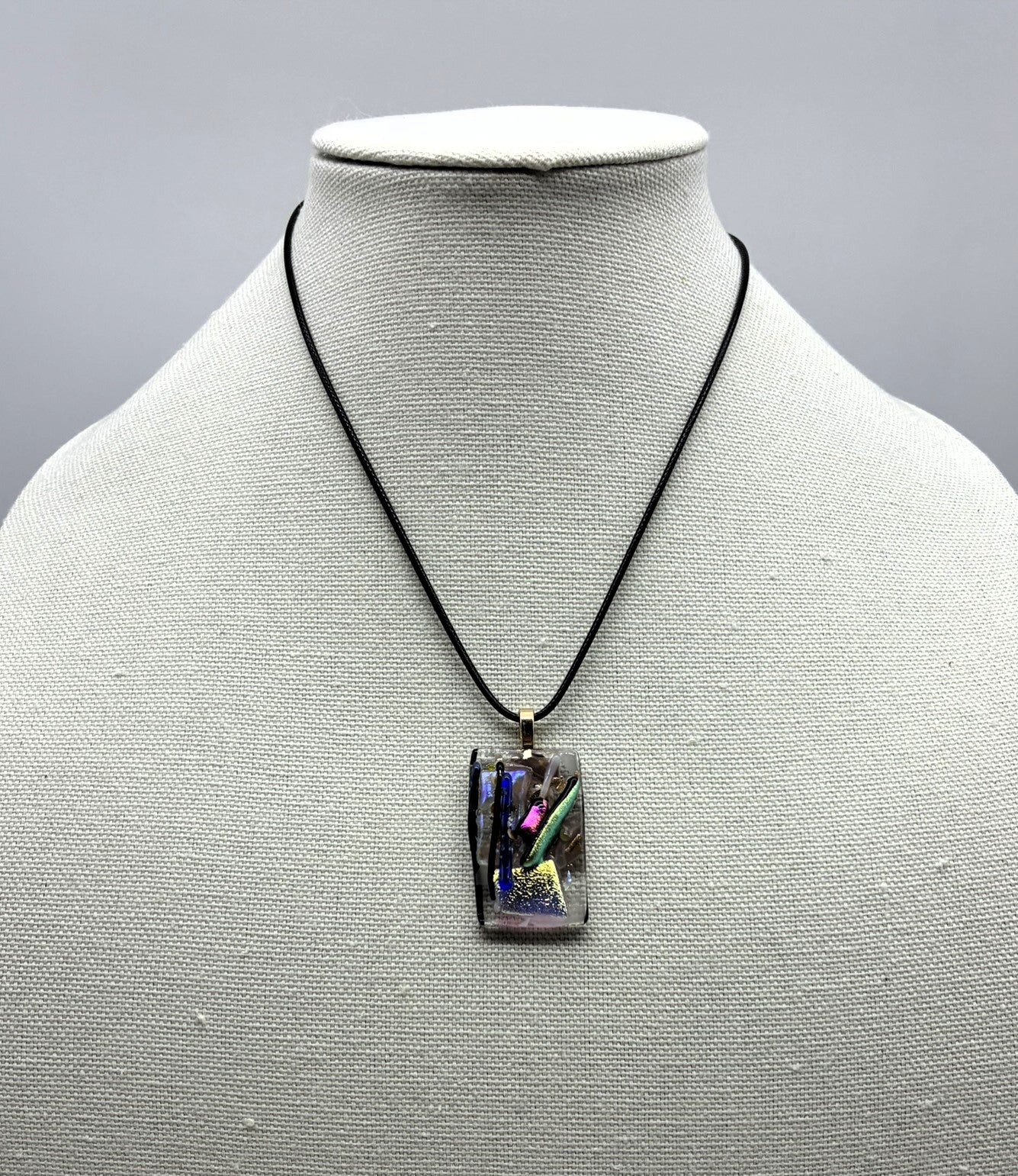 Jewelry - Small clear glass rectangle holding silver pot with a number colored sticks coming out of it.