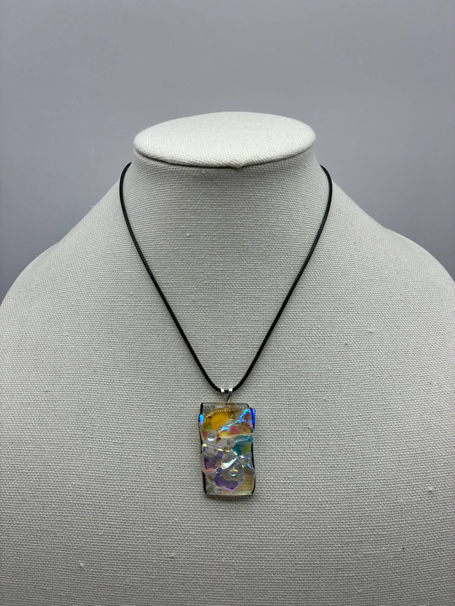 Jewelry - Small clear glass rectangle holding numerous pieces of cut and dichroic glass
